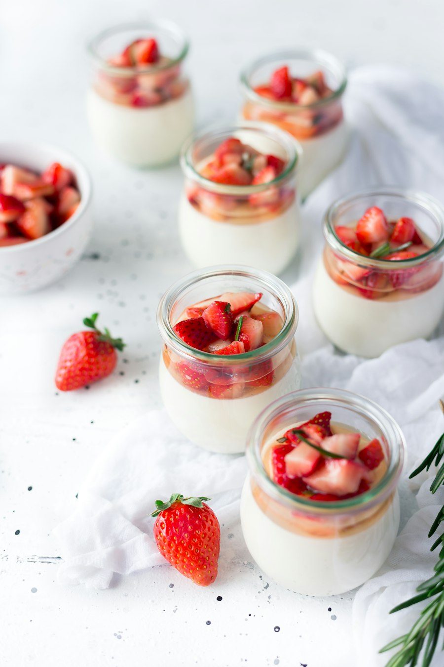 Tarritos de yogur natural con fresas troceadas y romero